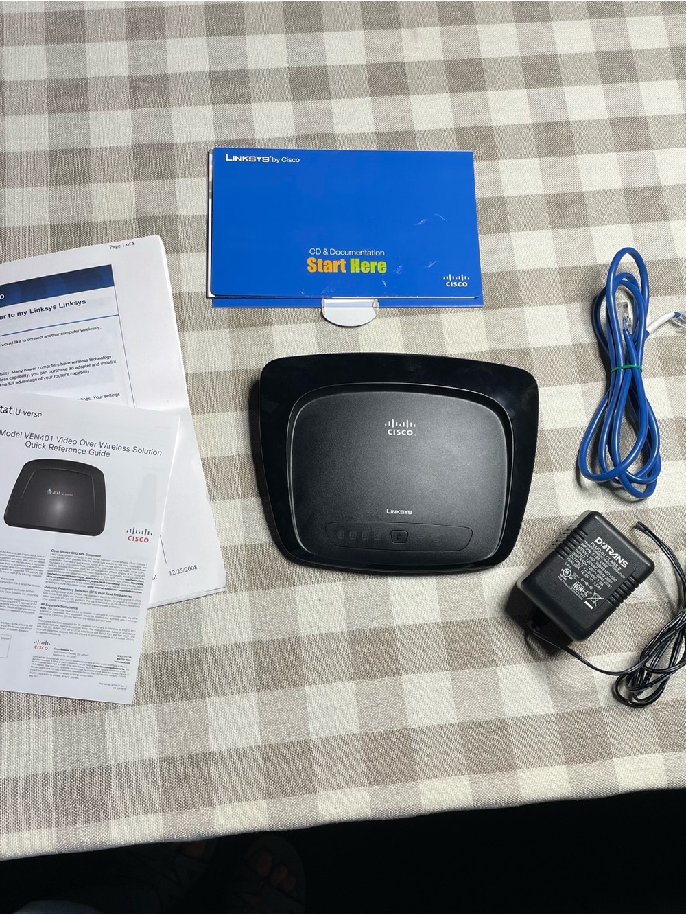 Linksys Black Wireless Router with Blue Ethernet Cable and Power Adapter